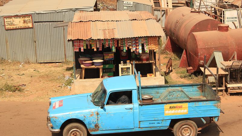 A pickup truck passing a roadside shop