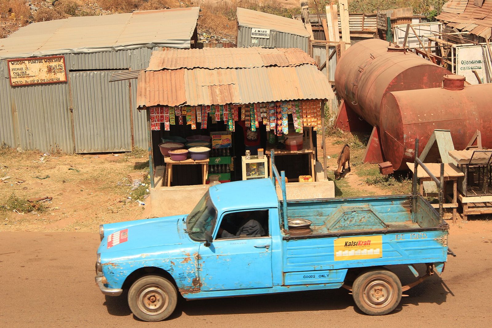 A pickup truck passing a roadside shop